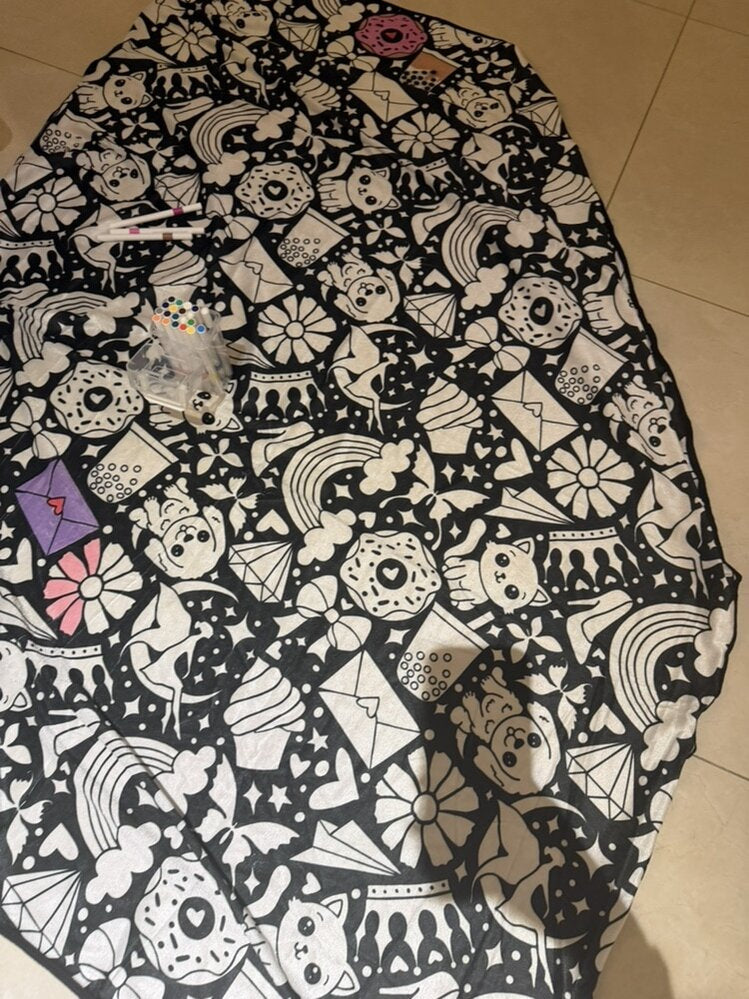 Folded doodle blanket on a bed